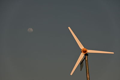 Low angle view of wind turbine against clear sky