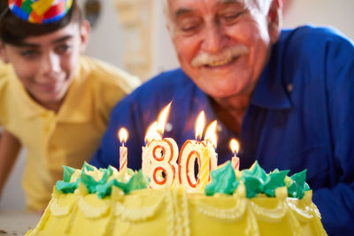 Senior man looking cake during birthday celebration