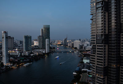 Top view cityscape of bangkok at chao phraya river in evening blue sky