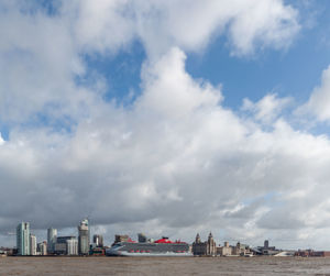 Buildings in city against cloudy sky