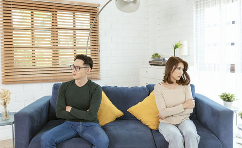 Young couple sitting on sofa at home