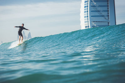 Man surfing in sea against sky