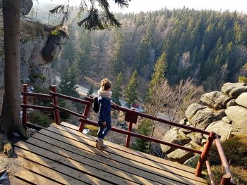 People on footbridge against mountains