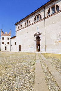 Old building by street against sky in city