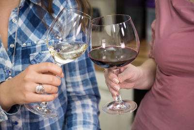 Midsection of woman holding wine