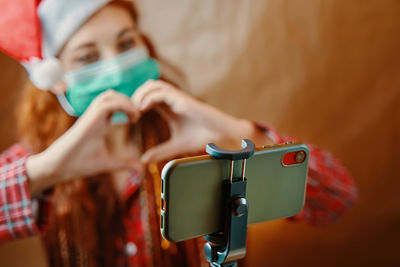 Close-up portrait of woman holding camera