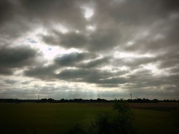 Scenic view of field against cloudy sky