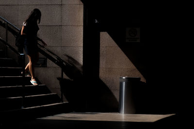 Full length of woman moving down on steps in subway