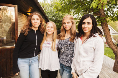 Portrait of confident teenage girls standing at yard