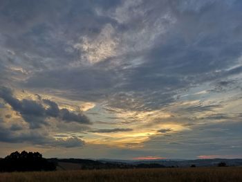 Scenic view of field against sky at sunset