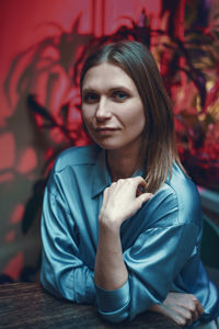 Woman sitting in a cafe at a table with a dreamy look