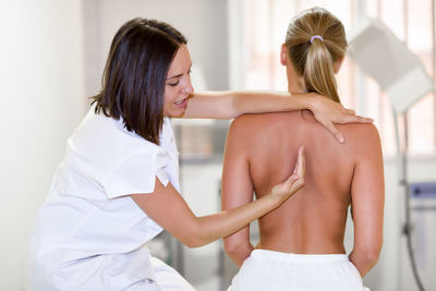 Physiotherapist examining female patient