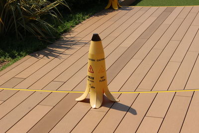 High angle view of yellow warning sign on footpath