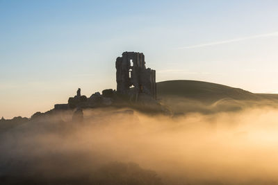 Castle on mountain against sky during sunset