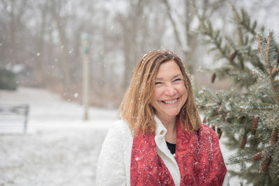 Portrait of smiling woman during snowfall