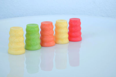 Close-up of multi colored candies in plate against white background
