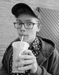 Black and white portrait of teenage boy drinking coffee and relaxing