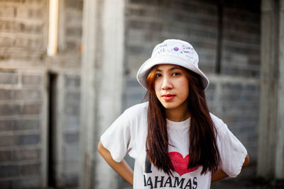 Portrait of woman standing at abandoned building