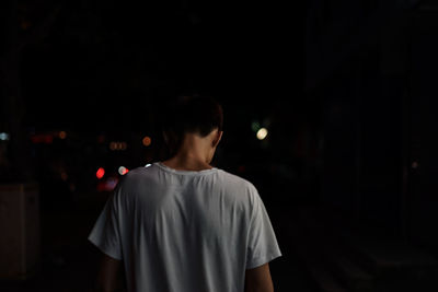 Rear view of a man standing at night
