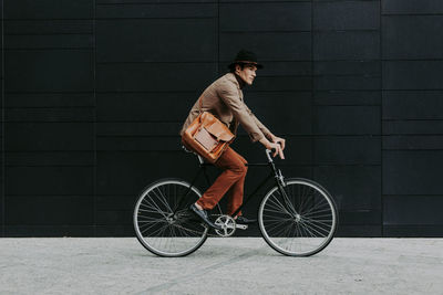 Man riding bicycle against wall