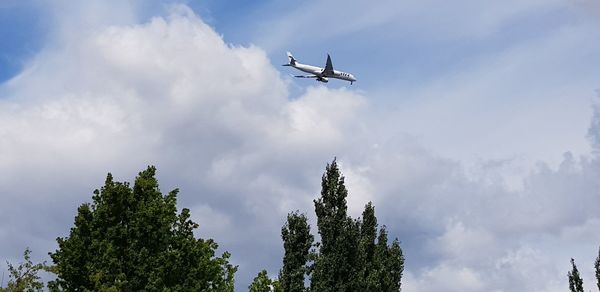 Low angle view of airplane flying against sky