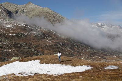 Rear view of woman standing on mountain during winter