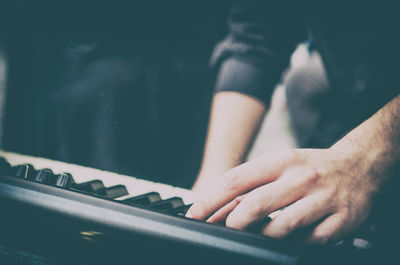 Cropped hands playing piano