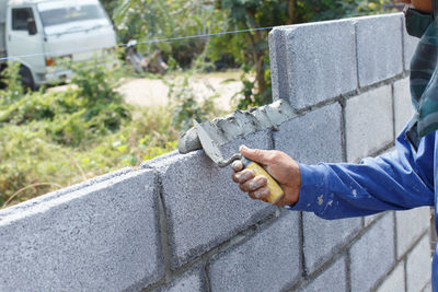 Man holding umbrella on retaining wall