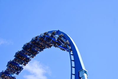 Low angle view of ferris wheel against blue sky