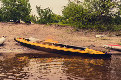 Boats moored in river against sky