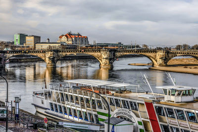 Bridge over river against cloudy sky