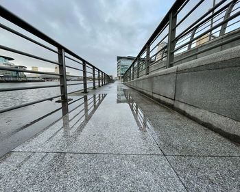 View of footbridge in city against sky