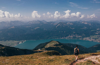 Woman in black sportswear and a small backpack with food meets famous austrian mountain schafberg