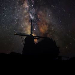 Low angle view of silhouette built structure against sky at night