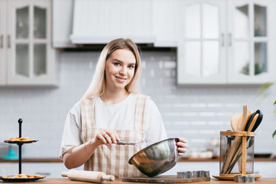 Portrait of smiling beautiful woman preparing cake