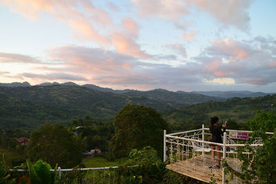 People looking at mountains against sky