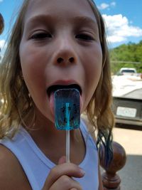Close-up portrait of girl licking lollipop
