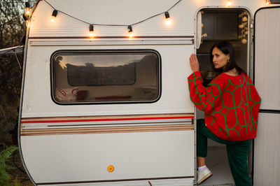 Portrait of young woman standing in train