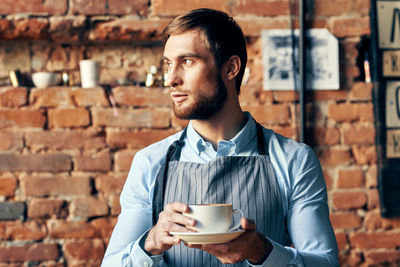 Portrait of young man drinking coffee at cafe