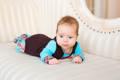 Portrait of cute baby lying on sofa