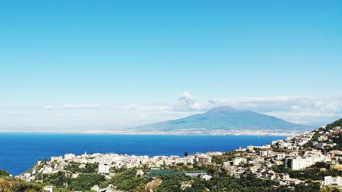 Scenic view of sea and buildings against blue sky