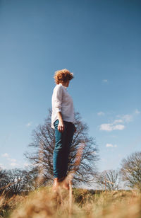 Full length of woman standing on tree trunk