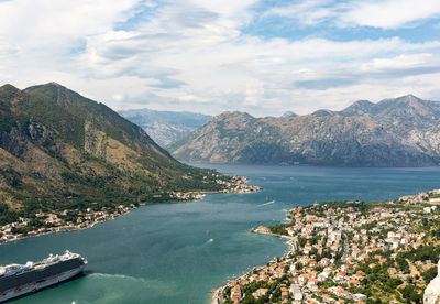 High angle view of town by sea against mountains