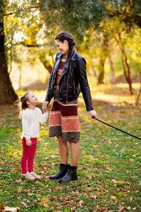 Full length of a girl standing against plants