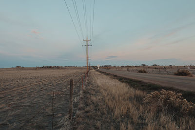 Electricity pylon on field against sky