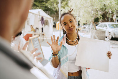 Female customer bargaining while holding record at flea market