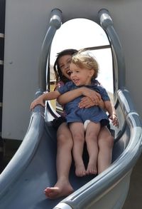 Siblings enjoying on slide