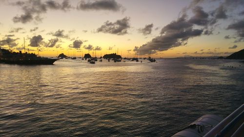 View of boats in sea against cloudy sky