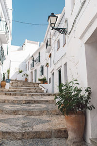 Low angle view of staircase amidst buildings against sky