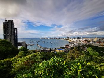 High angle view of city by sea against sky